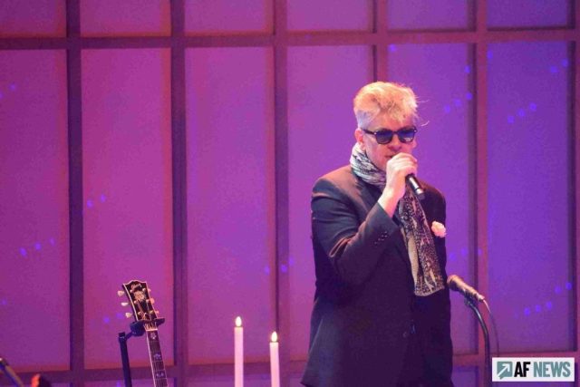 Le chanteur, peu loquace, lunettes noires sur le nez, œillet à la boutonnière de sa veste, fait le job